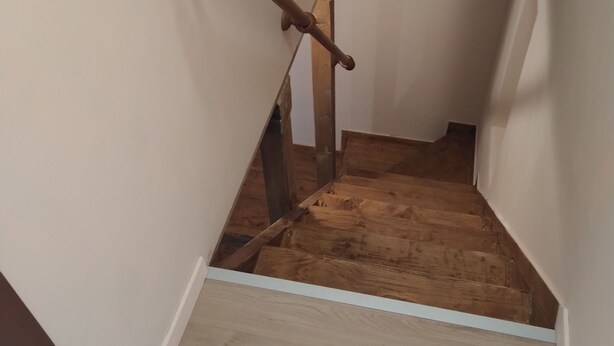 A wooden staircase with a metal handrail and a white wall. - Little House (Bracciano)