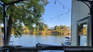 A view from a boat on a lake with a dock and a building in the background. - Lake Haven (Hot Tub, Game Room) (Hot Springs)