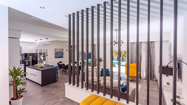 Un espace de vie moderne comprenant une cuisine, un coin repas et un espace piscine.