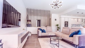 Un salon moderne avec un canapé, une table basse et un téléviseur fixé au mur.