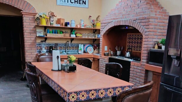A kitchen with a brick oven, a tiled backsplash, and a sign that reads "KITCHEN". - Huerta Ariana  (Parras de la Fuente)