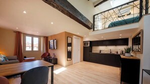 Eine moderne Wohnung mit Essbereich, Küche und einer Schlafgalerie.