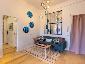 Una sala de estar moderna con un sofá, una mesa de centro, un espejo y platos decorativos en la pared.