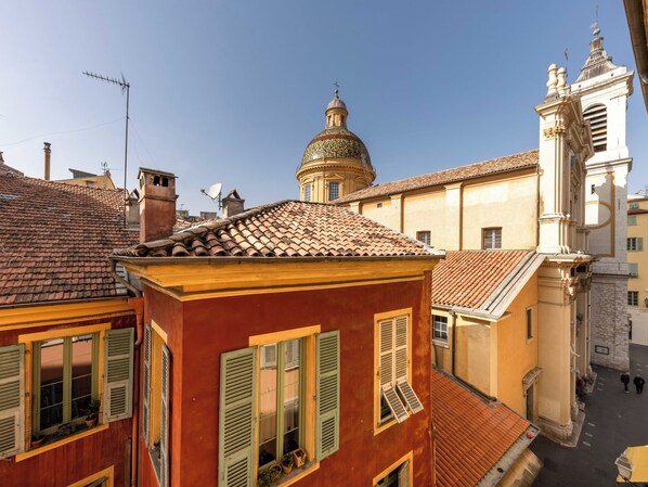 A street view with buildings, a dome, and a bell tower.