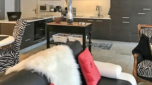 A modern living room with a black and white sofa, a zebra-patterned chair, and a small side table with a vase and a bowl. - Pet friendly home in CAVAILLON (CAVAILLON)