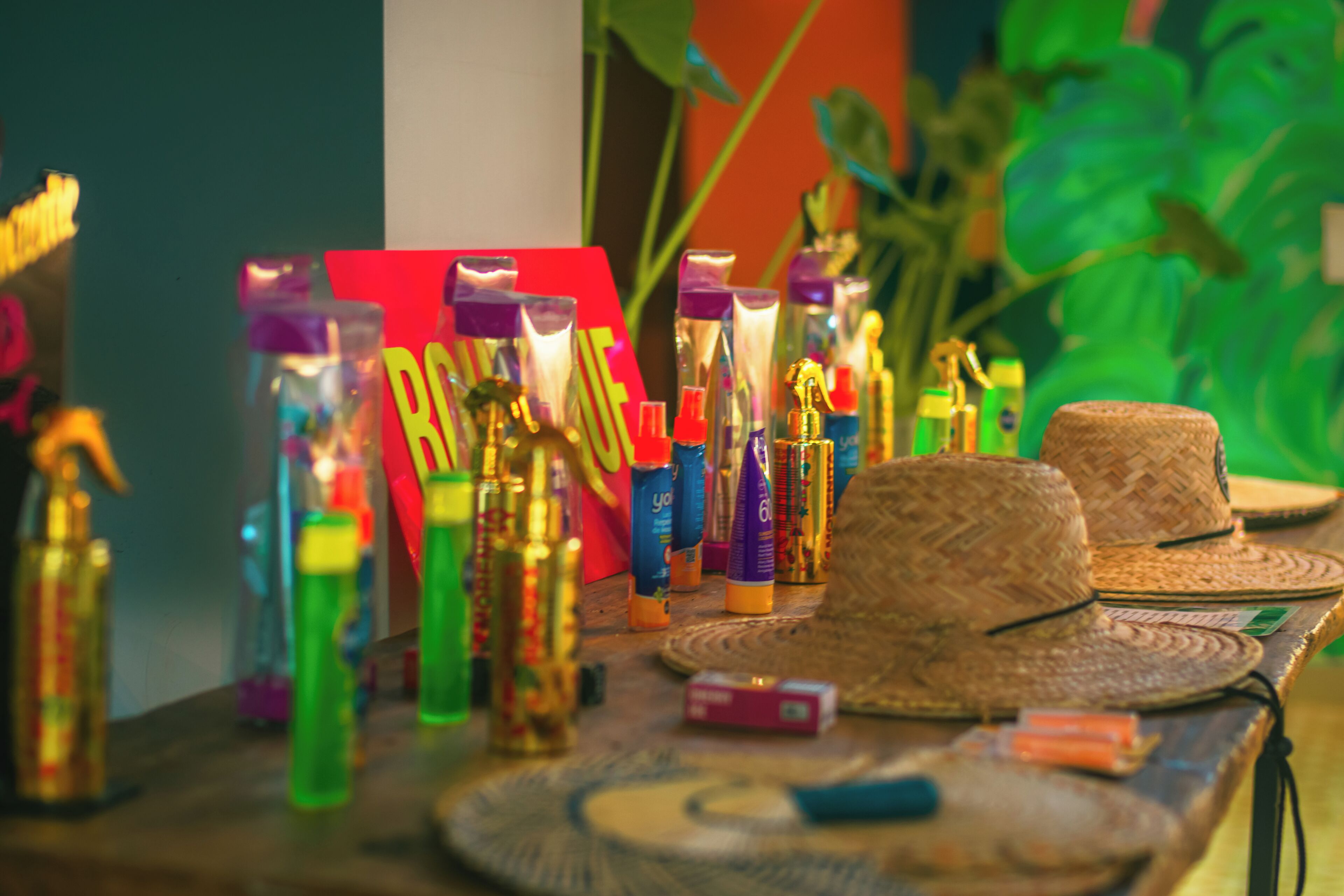 Una mesa con artículos de tocador y sombreros tejidos.