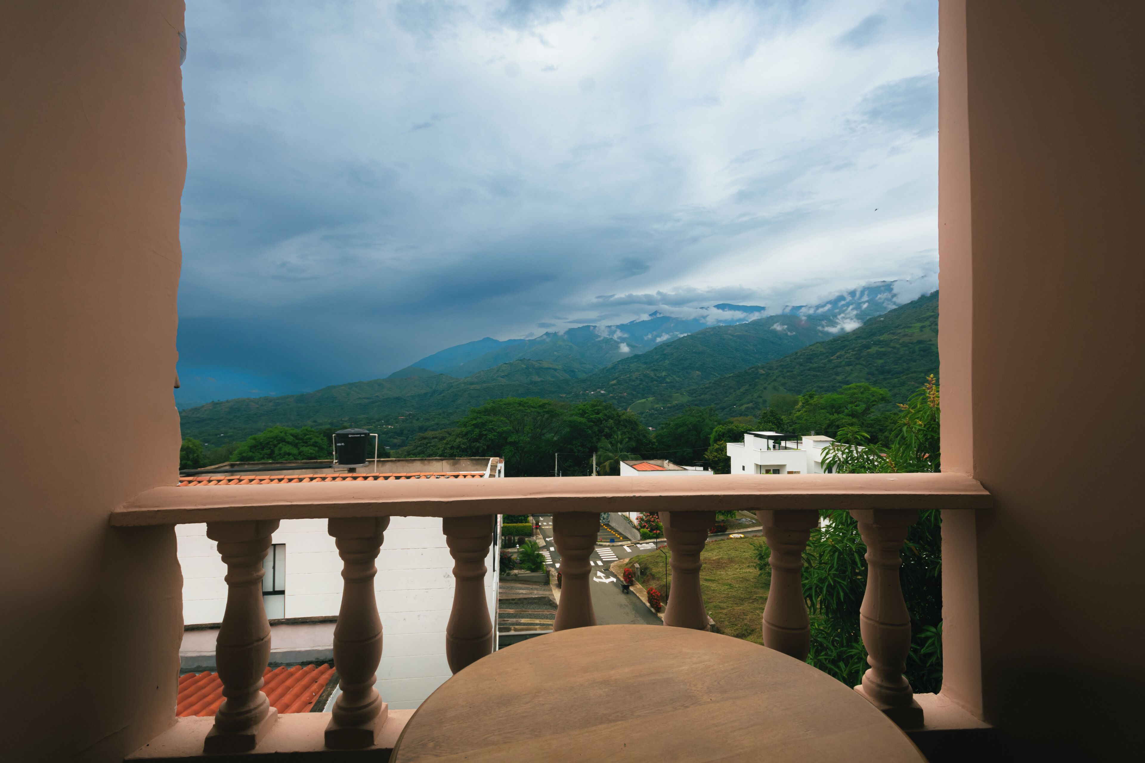 A balcony with a view of a mountain range and a road below.