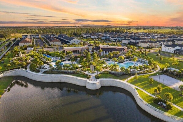 A residential area with houses, a swimming pool, and a body of water.