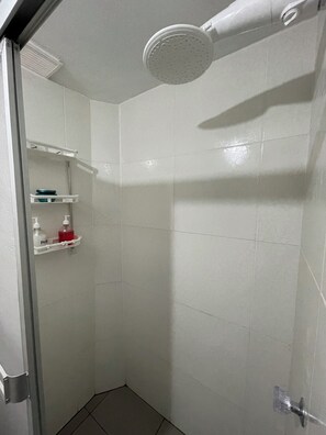 Een douche, handdoeken, zeep, toiletpapier