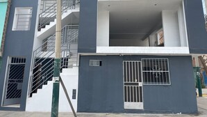 Um edifício de vários andares com escadas, varandas e janelas com grades.