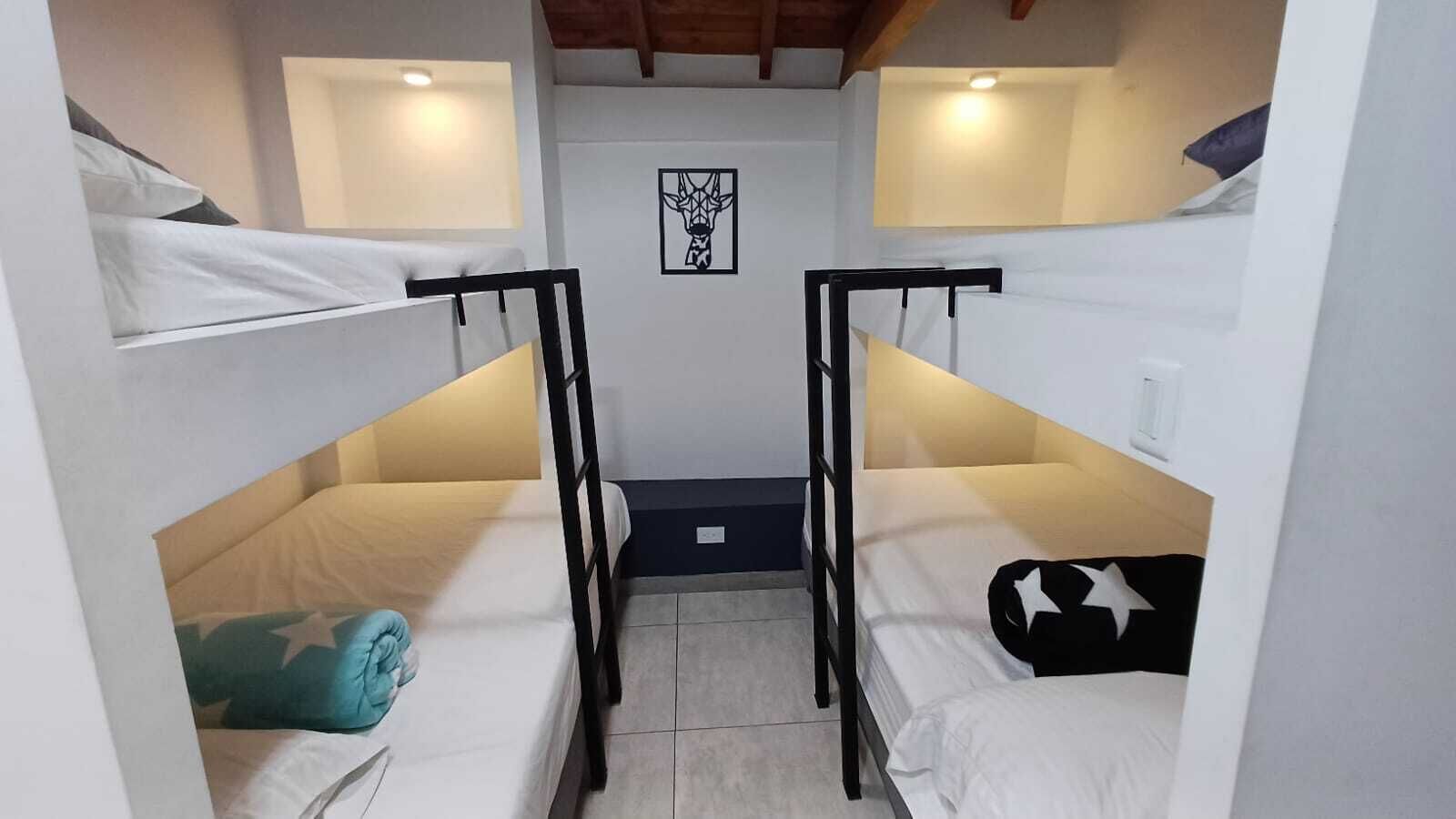 Un dormitorio con literas, un cuadro en la pared y una ventana pequeña.