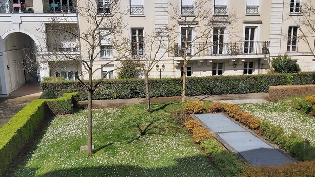 A building with multiple balconies and a courtyard with trees and a small water feature. - 850 metres from Disney Land and Valley Village - 3 bedrooms - Sleeps 8 (Serris)