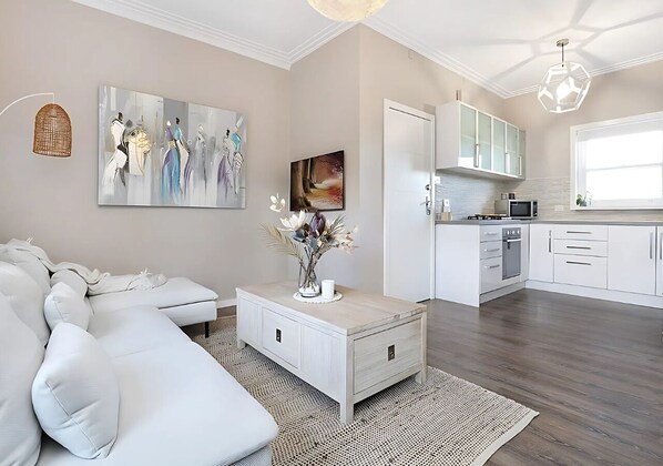 Relax in this stylish living room with a white sectional sofa, coffee table, and abstract art.