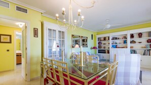 A dining area with a glass table and chairs, a chandelier, and a white cabinet with shelves. - Pet friendly apartment in El Campello (El Campello)