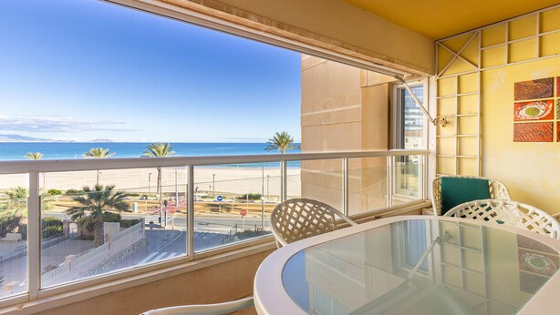 A balcony with a glass table and chairs, overlooking a beach and the sea. - Pet friendly apartment in El Campello (El Campello)