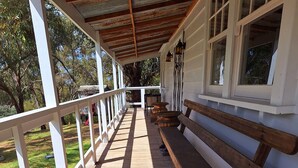 A wooden deck with benches, white railings, and a covered area with windows. - Havana Villa MALDON (Maldon)