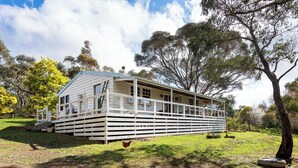 A two-story house with a porch, surrounded by trees and grass. - Havana Villa MALDON (Maldon)