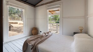 A bedroom with a bed, a wicker basket, and a nightstand with a lamp. - Havana Villa MALDON (Maldon)