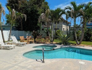 A swimming pool with lounge chairs and a palm tree. - Hibiscus Hideaway: Pool, Spa & Steps to the beach (Cocoa Beach)
