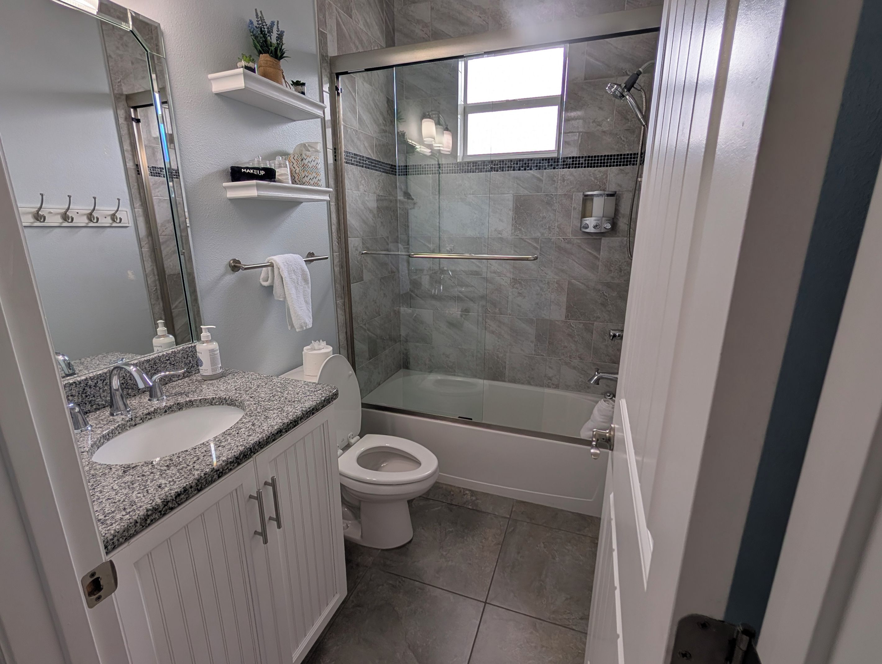 Ein modernes Badezimmer mit Marmorwaschtisch, Toilette, einer Duschkabine und einer Badewanne.