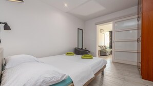 Ein Schlafzimmer mit einem Bett, einem Nachttisch, einem Spiegel und einem Kleiderschrank.