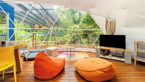 A tent-style room with a television, seating, and a table.