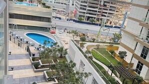 A modern residential building with a rooftop swimming pool, landscaped gardens, and a view of the city skyline. - Khalifa Holiday's  (Dubai)