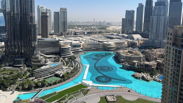 A high-rise building complex with a large, central swimming pool surrounded by modern architecture. - Khalifa Holiday's  (Dubai)