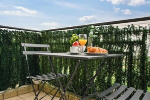 Enjoy a romantic meal for two in this serene outdoor dining area, complete with a table set and a beautiful hedge backdrop.