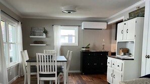 A compact living space with a dining area, kitchenette, and a small seating area.