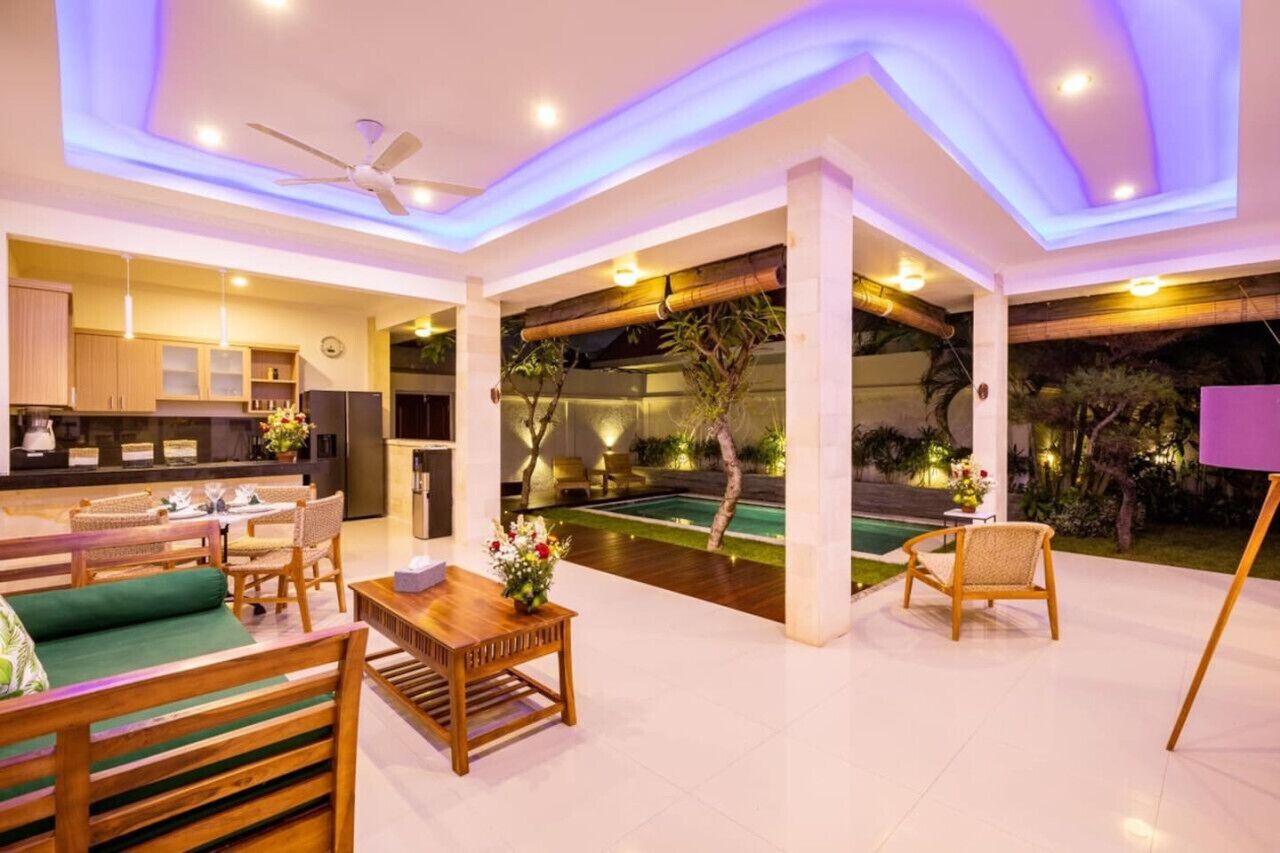A spacious living area with a pool, wooden furniture, and a modern ceiling design.