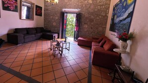 Ein Wohnzimmer mit Steinwand, einer Couch, einem Couchtisch und einem Gemälde.