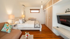 Ein Schlafzimmer mit Bett, Nachttischen, einem Fernseher und einem Kleiderschrank.