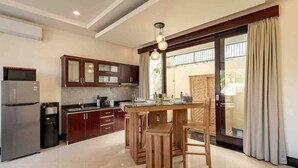 A modern kitchen with a central island, dark wooden cabinets, and a stainless steel refrigerator. - 2 Bedroom private Pool Seminyak (seminyak)
