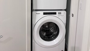 Pesuhuone, jossa on kaksi päällekkäin asetettua Whirlpool-merkkiä olevaa pesukonetta.