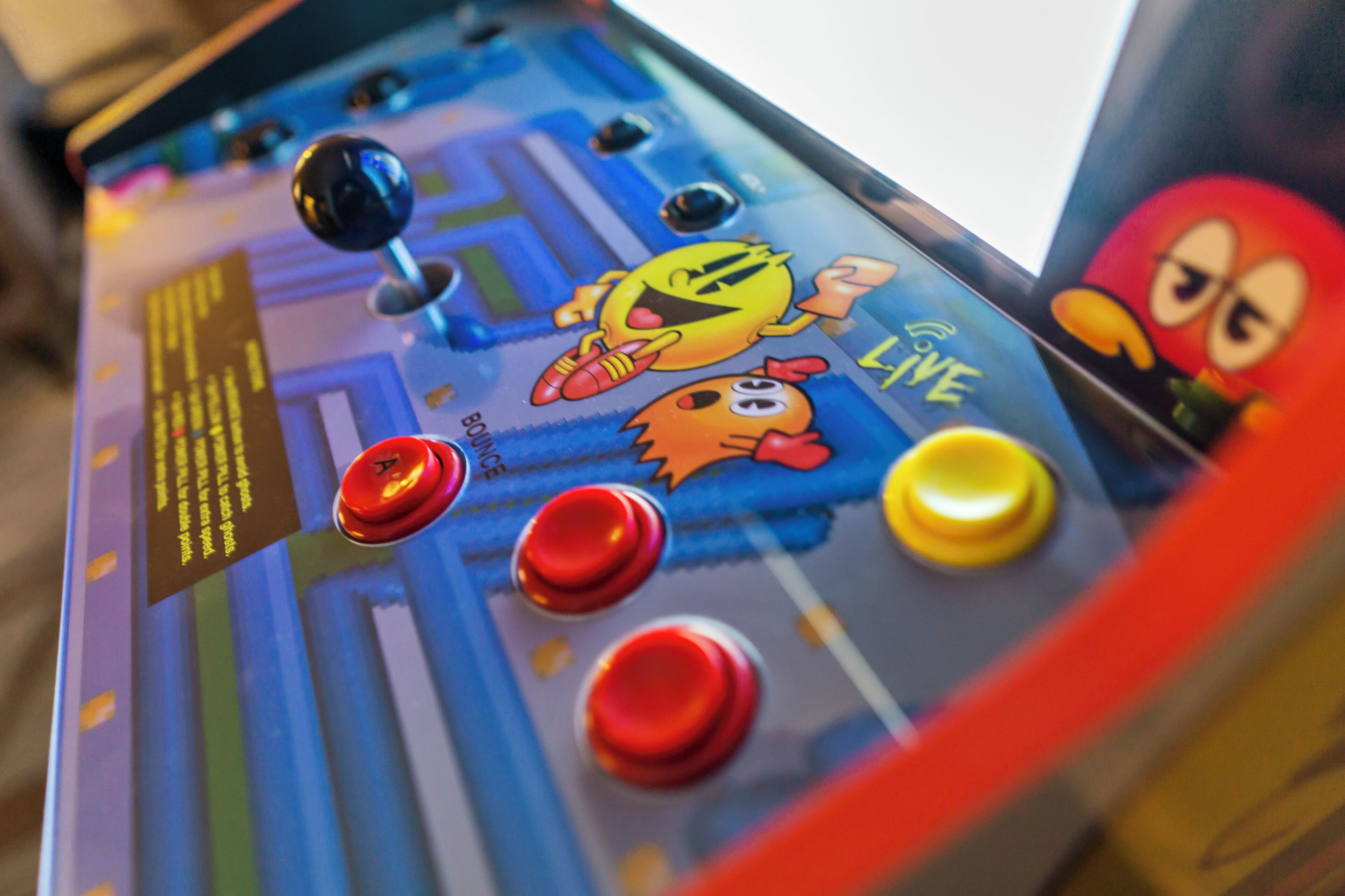Un panneau de commande doté de boutons colorés et d’un joystick.