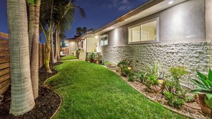A modern house with a stone exterior, a well-maintained lawn, and various potted plants. - San Diego City Escape – Perfect for Families, Groups, & Business Travelers (San Diego)