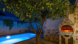 A stone pool with a tree in the center, a stone wall, and a brick oven. - Your private couples haven in Corfu (Halikounas)