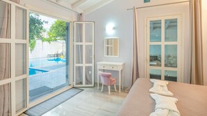 A bedroom with a bed, a desk, a chair, a window, and a door. - Your private couples haven in Corfu (Halikounas)