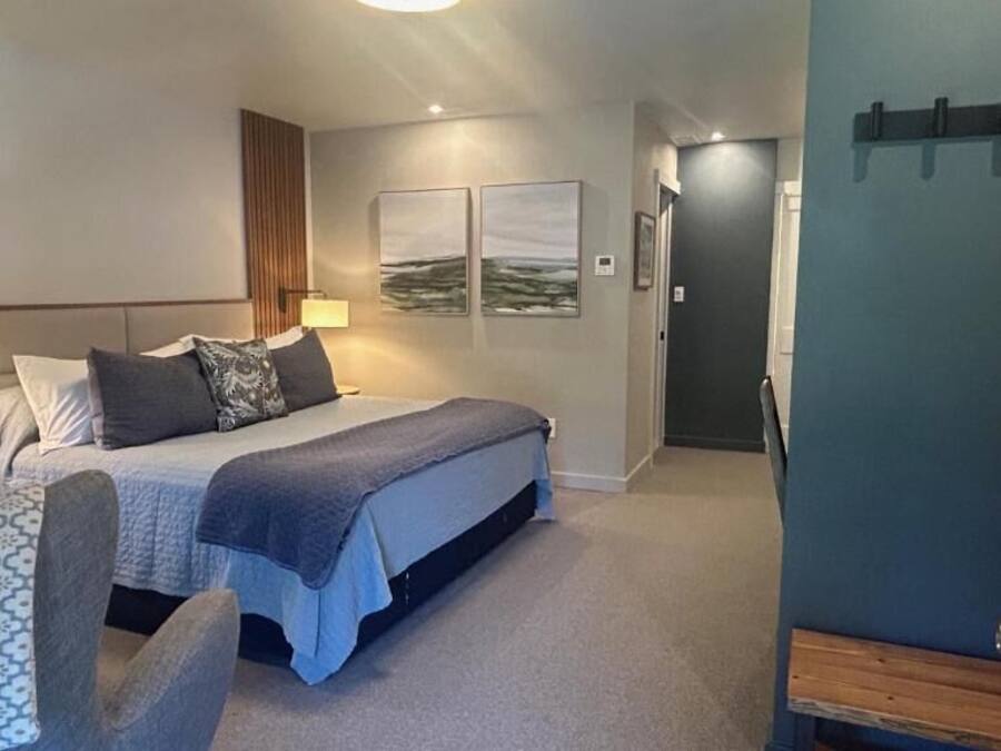 A modern bedroom with a bed, bedside tables, and a door.