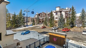Un quartiere residenziale con piscina, patio recintato e vista su una seggiovia.