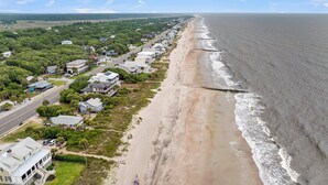 Un pueblo costero con propiedades frente a la playa, una calle principal y una playa.