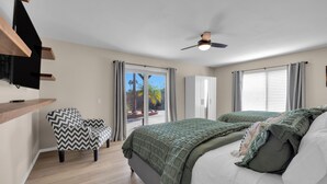Un dormitorio con cama, una silla, armario y ventilador de techo.