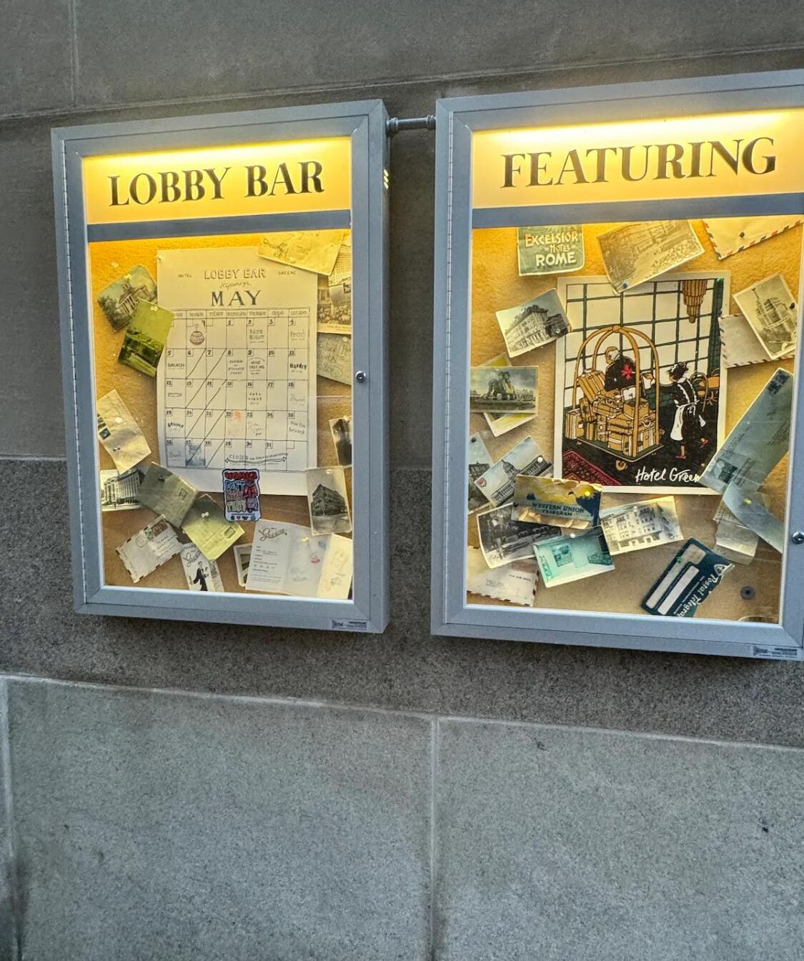 Deux panneaux d  ’affichage, l’un portant l’inscription « Bar du hall » et l’autre « À l’affiche », présentent divers objets de collection liés à l’hôtel et un calendrier pour le mois de mai.