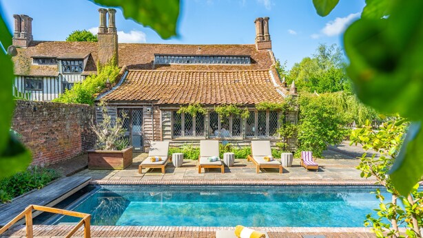A traditional house with a swimming pool, surrounded by greenery and equipped with lounge chairs. - Splendid 1,000 year old Medieval manor house  sleeps up to 14 or 22- Flemings Hall (Ipswich)