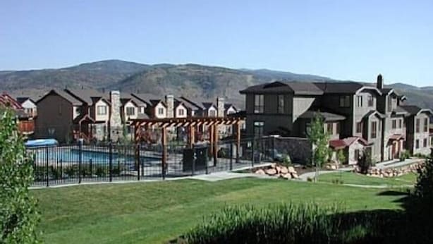 Zona residencial con casas, piscina y pérgola.