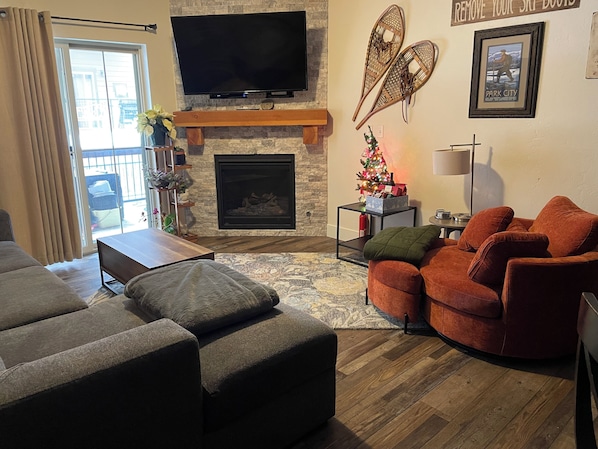 Una sala de estar con chimenea, un televisor de pantalla plana y un árbol de Navidad.