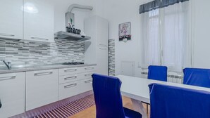 A modern kitchen with white cabinets, a gas stove, and a 'BAR' sign above the stove. - GuestHost - Comfy APT in Genoa's St. Theodore District (Genova)