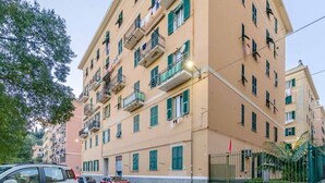 A multi-story residential building with balconies, a gated entrance, and a street view. - GuestHost - Comfy APT in Genoa's St. Theodore District (Genova)