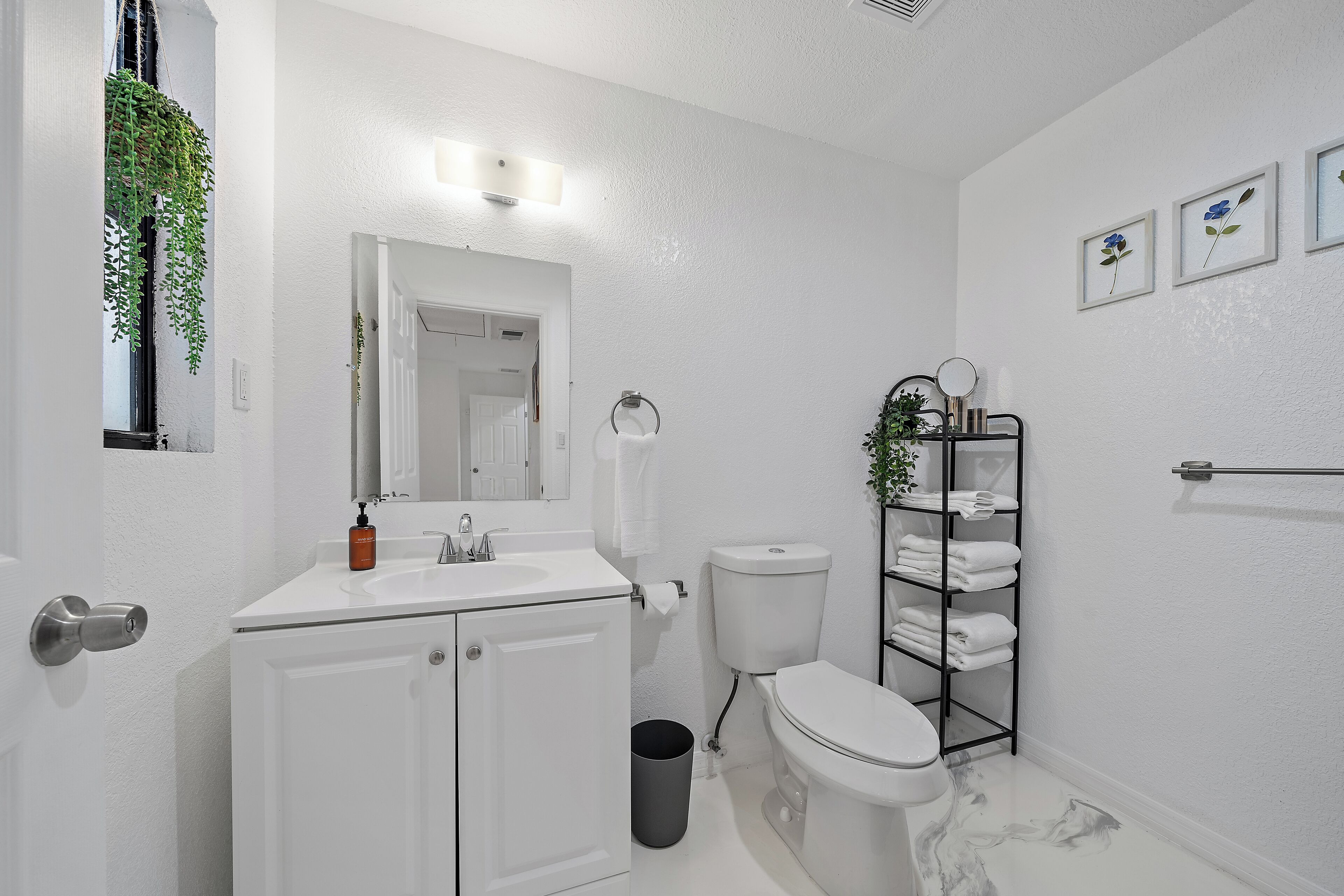 Une salle de bain moderne avec un lavabo blanc, des toilettes et un porte-serviettes.
